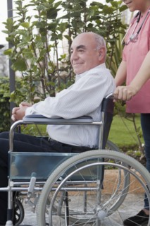 Hispanic nurse pushing patient in wheelchair