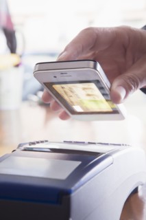 Hispanic woman scanning credit card from cell phone