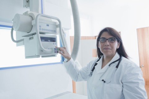 Hispanic doctor using x-ray in hospital
