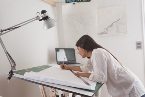 Hispanic architect drawing at drafting table
