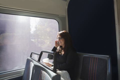 Hispanic woman talking on cell phone on train