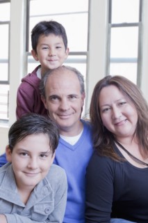 Hispanic mother and father posing with sons