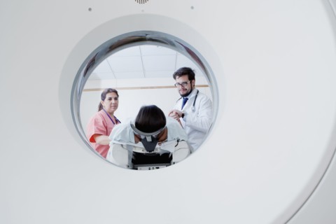Hispanic doctor and nurse preparing patient for scanner
