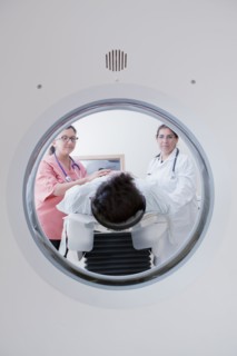 Hispanic doctor and nurse comforting patient at scanner