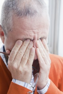 Hispanic man rubbing eyes