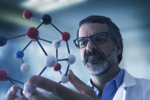 Hispanic scientist examining molecule model