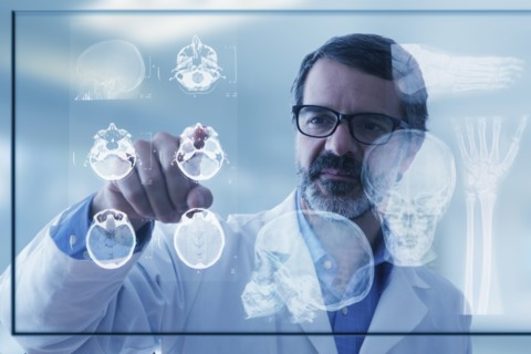 Hispanic doctor examining x-rays on virtual screen