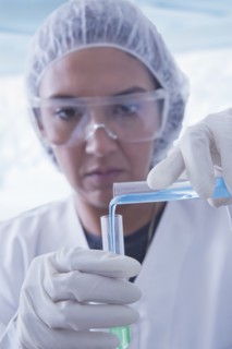 Hispanic scientist pouring liquid into test tube
