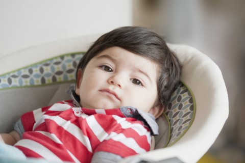Hispanic baby boy laying in bassinet