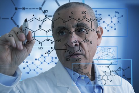 Hispanic scientist writing formula on glass wall