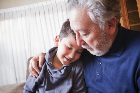 Hispanic grandfather hugging grandson