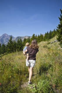 Mother carrying son on remote mountain path