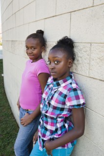 Black girls leaning against wall