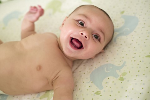 Smiling baby laying on blanket
