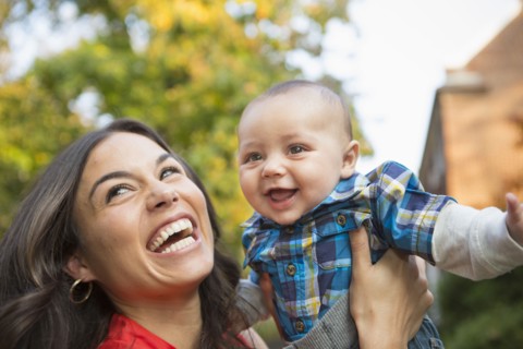 Smiling mother holding baby outdoors