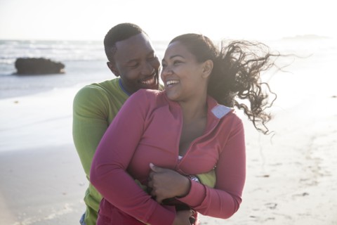 Smiling couple hugging on beach