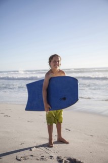 Caucasian by carrying boogie board on beach