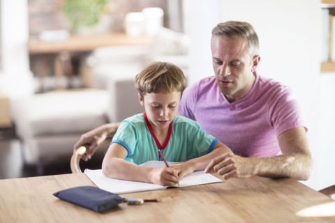 Caucasian father and son drawing at table