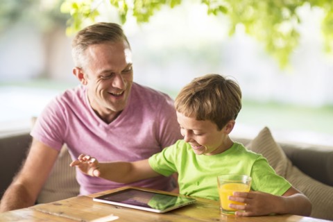 Caucasian father and son using digital tablet outdoors
