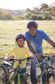 Caucasian father and son riding bicycles on dirt path