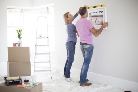 Caucasian couple using level in new home