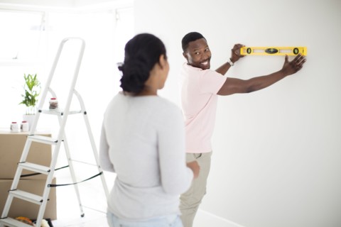Couple using level in new home