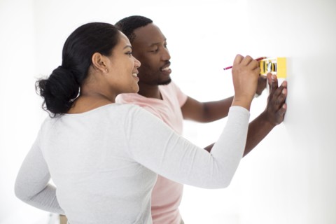 Couple using level in new home