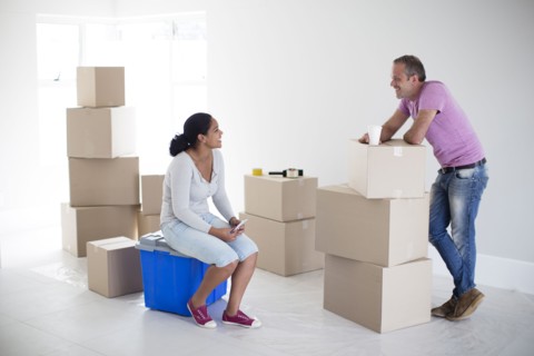Couple with cardboard boxes in new home