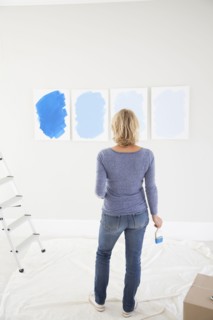 Caucasian woman examining paint samples in new home