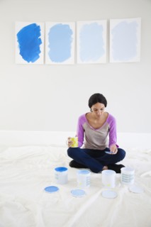 Mixed race woman examining paint samples in new home