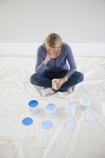 Caucasian woman examining paint samples in new home