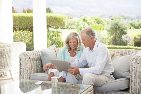 Caucasian couple using digital tablet on sofa outdoors