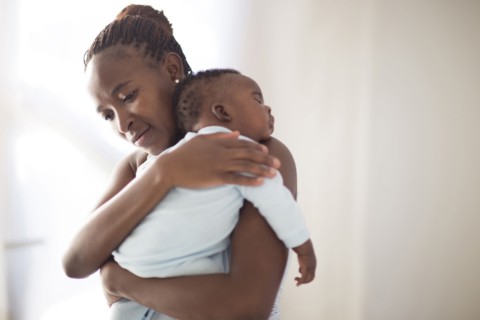 Black mother holding sleeping baby