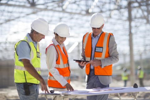Architects reading blueprints at construction site