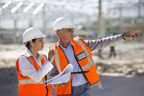 Architects reading blueprints at construction site