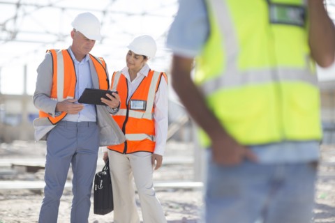 Architects using digital tablet at construction site
