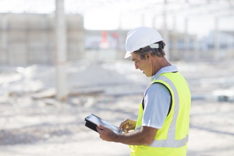 Caucasian architect using digital tablet at construction site