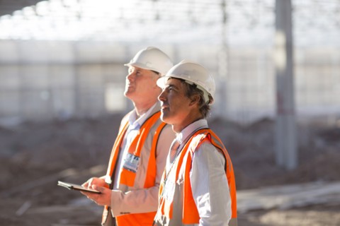 Caucasian architects using digital tablet at construction site