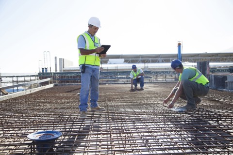 Construction workers arranging rebar at construction site
