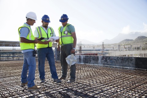 Construction workers talking on rebar at construction site