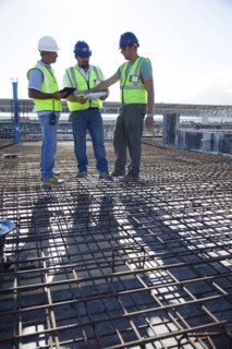 Construction workers talking on rebar at construction site