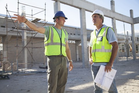 Caucasian construction workers talking at construction site