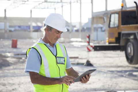 Caucasian construction worker using digital tablet at construction site