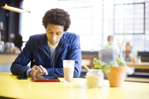 Man using digital tablet in cafe