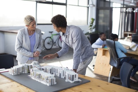 Architects examining architectural model in office