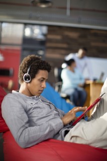 Mixed race businessman using digital tablet in office lounge