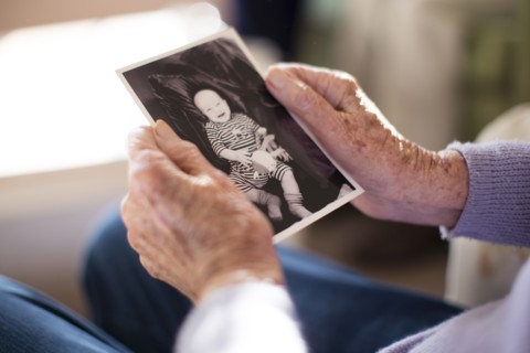 Caucasian woman admiring photograph of baby