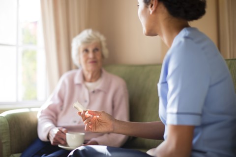 Nurse and patient drinking tea on sofa