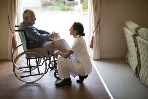 Nurse talking to patient in wheelchair