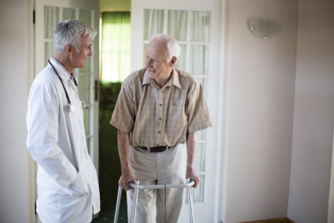 Doctor talking to patient using walker